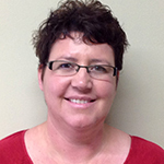 Portrait of woman with short dark hair wearing glasses and a red shirt.