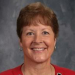 Portrait of a woman with short dark hair wearing a red shirt.
