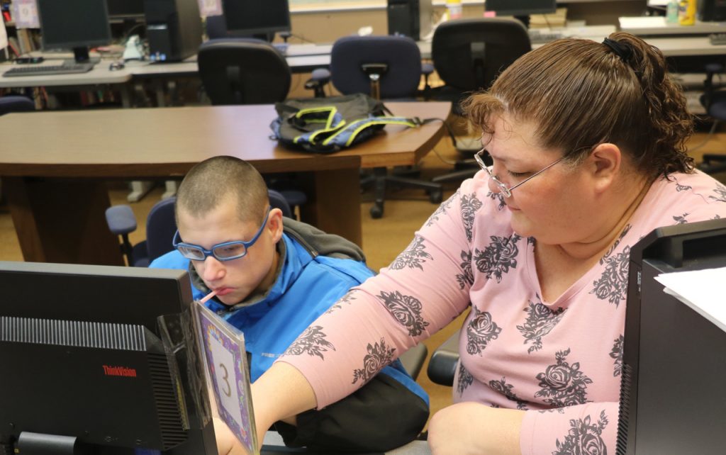 Teacher, Rebecca Epple, helping a student work on the computer.