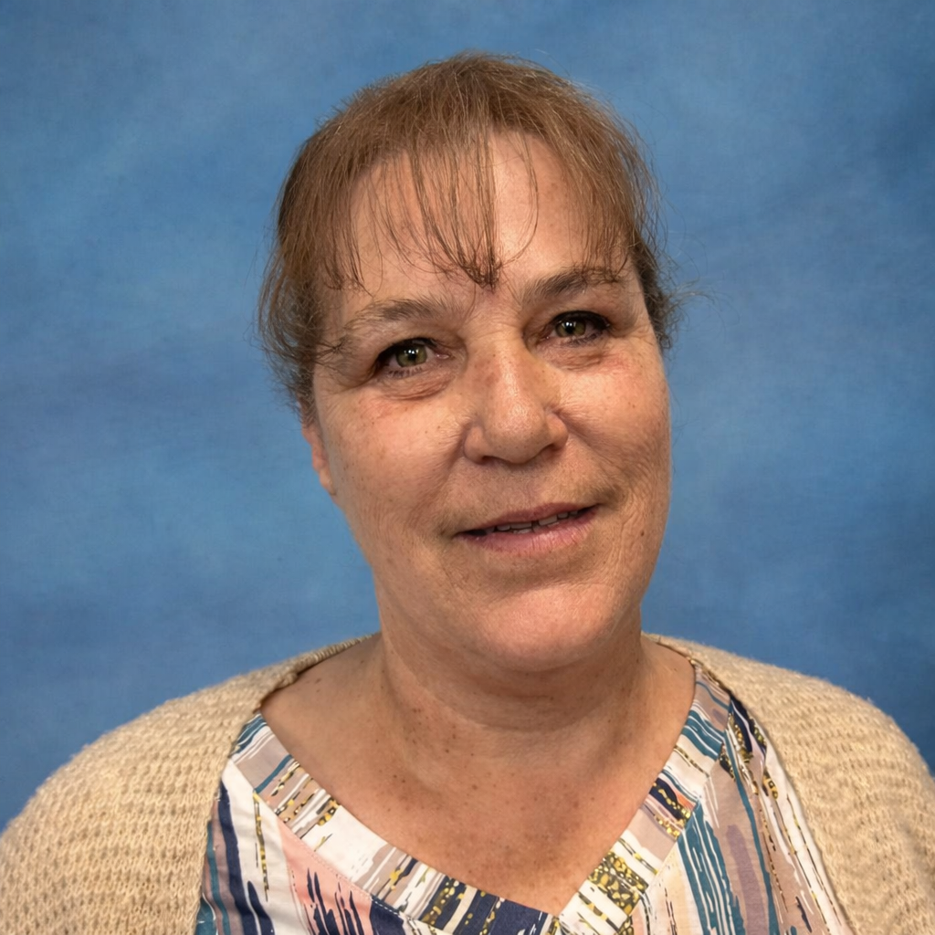 Professional headshot of a woman with a tan shirt against a blue background.