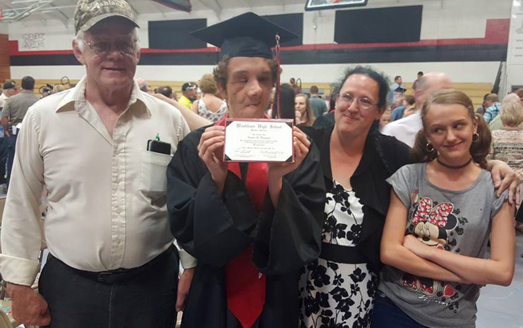 Family of four posing for photo at son's graduation.