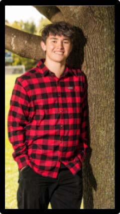 Jonah, a 2024 graduate, is leaning against a large tree in a black and red plaid button-up shirt for his Senior photo