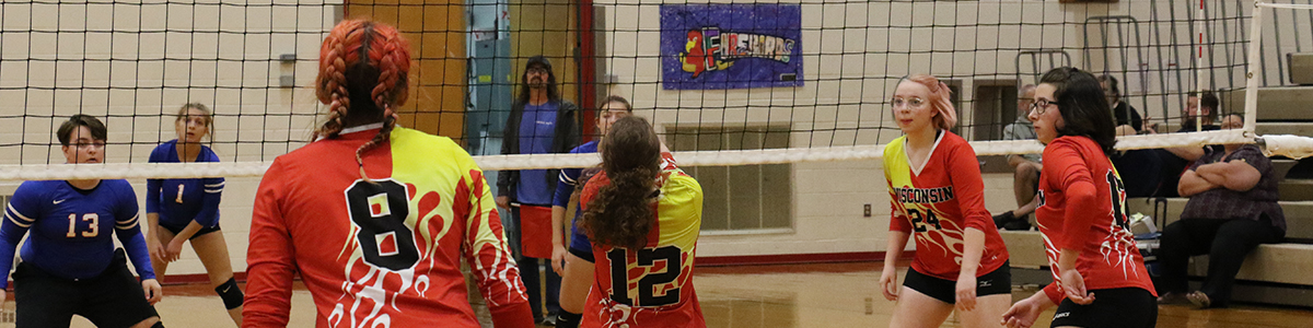 Seven students playing volleyball.